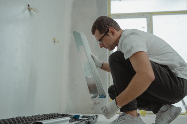 A man repairing something on the wall